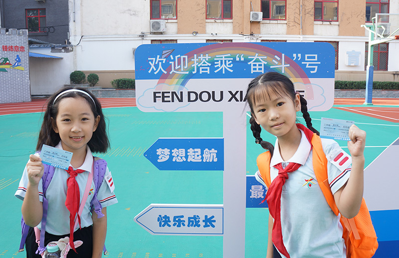9月1日,北京市西城区奋斗小学的师生们迎来了新的学期。校园内放置的“奋斗号”火车造型,车厢设计对应各年级,并在车门处安排投票口供学生投入车票。图为学生们手持车票,准备踏上“奋斗号”火车,开启新的旅程。